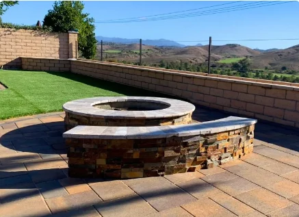 Stone fire pit and masonry seating wall at an Orange County hillside property
