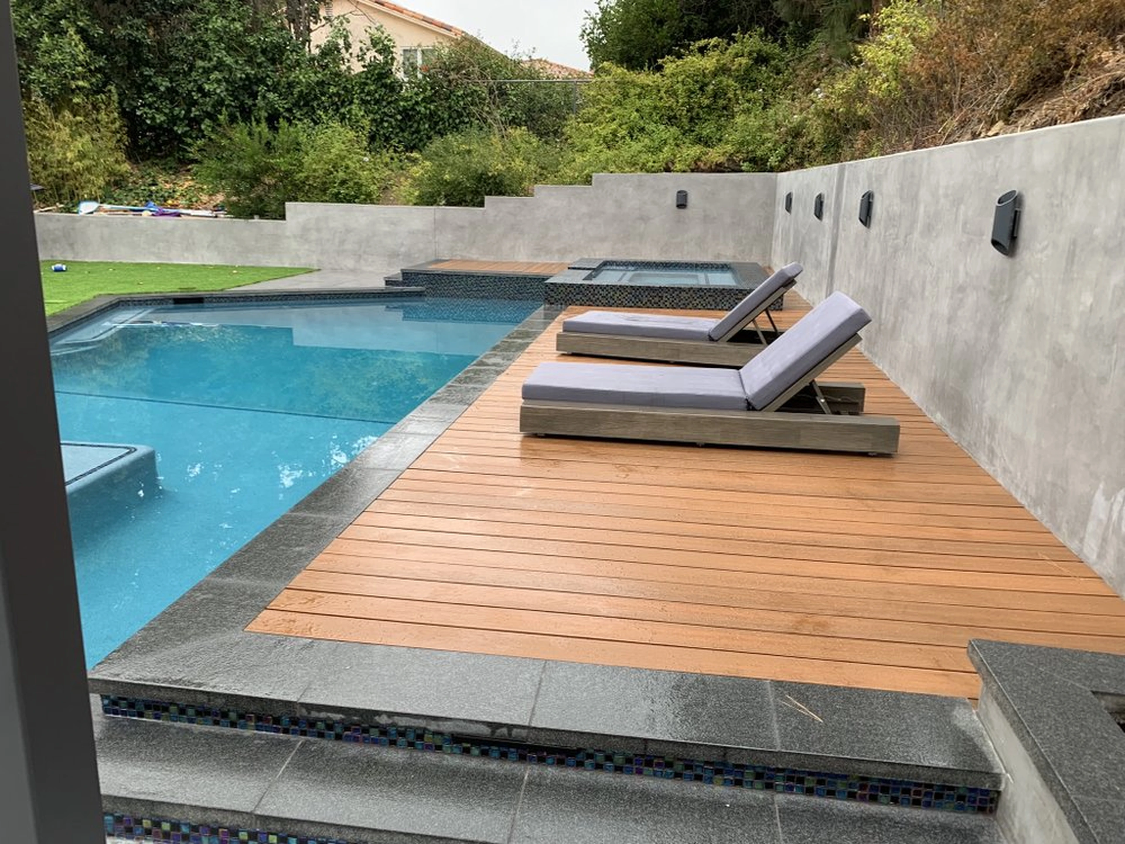 Completed Orange Park Acres pool deck with wood-look deck surface, pool, and spa improvements