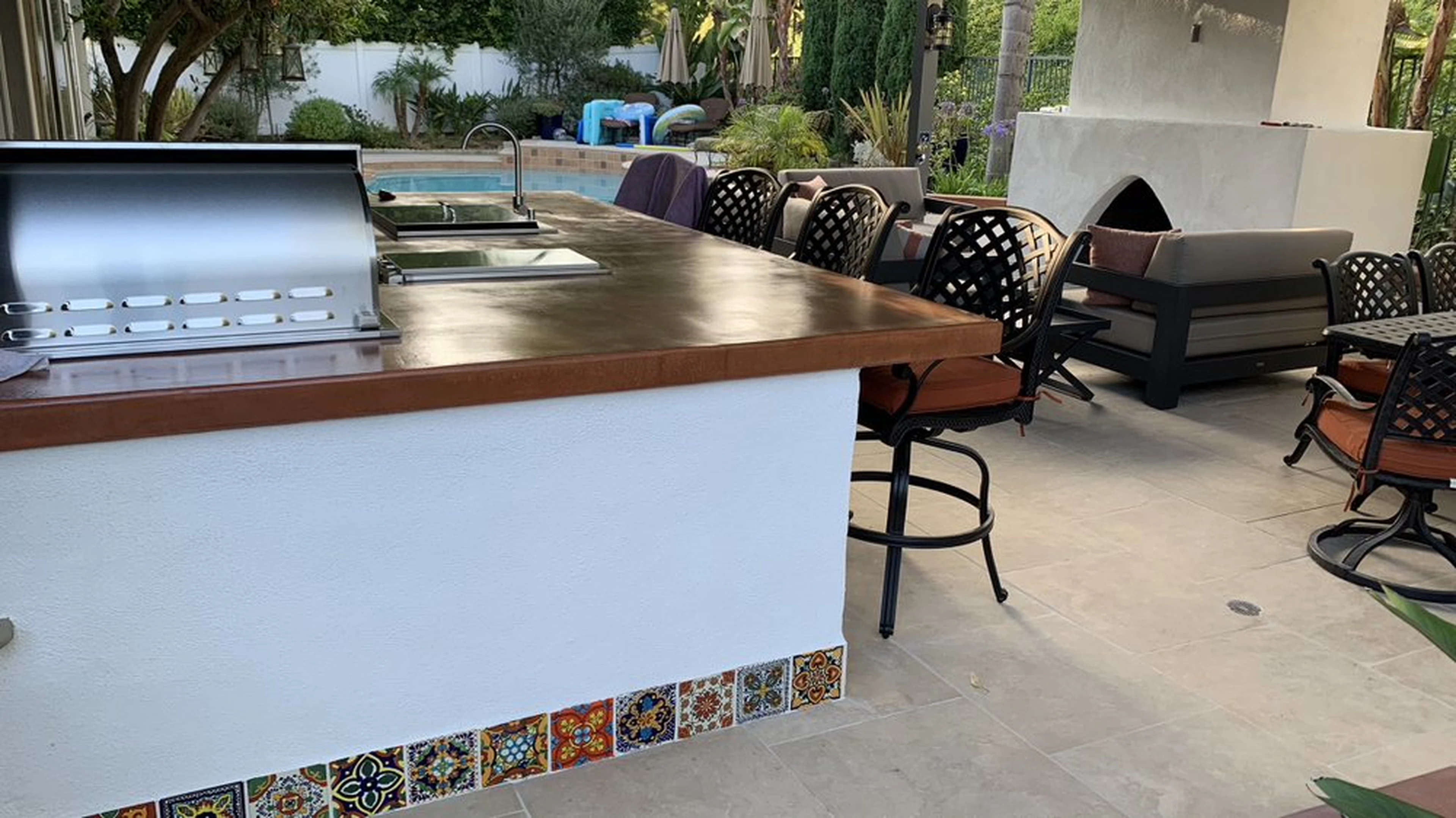 Completed Spanish-style outdoor kitchen with decorative tile accents and built-in barbecue island